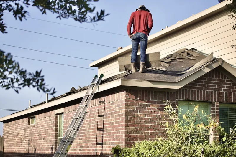 Professional roofer working on a residential roof in Second Ward